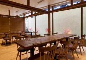 a dining room with a large wooden table and chairs at APA Hotel Kanazawa Ekimae in Kanazawa