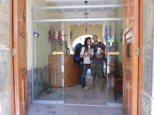 a group of three people standing in a glass doorway at OkiDoki Cusco Hostal in Cusco
