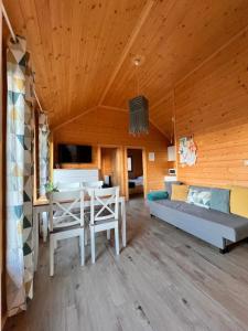 una sala de estar con una mesa y un sofá en Domki Habzówka, en Ostre