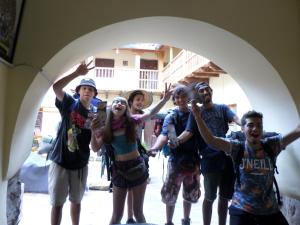 a group of people posing for a picture under an arch at OkiDoki Cusco Hostal in Cusco