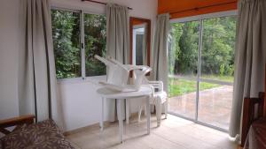a white table and chairs in a room with windows at Cabañas OliBer in Potrero de los Funes