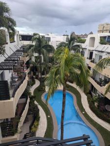 une vue aérienne d'un complexe avec piscine et palmiers dans l'établissement Peregrina 2 bdr In Heart of Playa, à Playa del Carmen