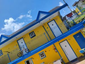 a yellow building with a bike on it at Pousada Cantinho da Mi & Teco in Campos do Jordão