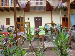 a house with a table and chairs and flowers at OkiDoki Cusco Hostal in Cusco