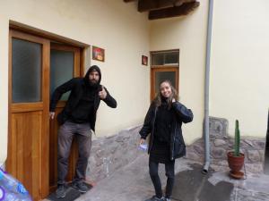 a man and a woman standing next to a building at OkiDoki Cusco Hostal in Cusco