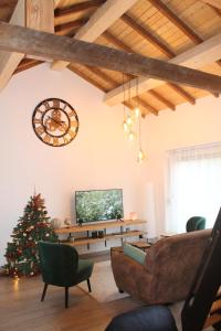 a living room with a christmas tree and a clock at Vakantiehuis Bernadette in Heuvelland