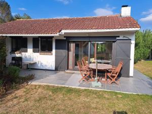 a house with a table and chairs on a patio at Vakantiehuis Bernadette in Heuvelland