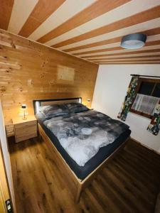 プフンツにあるApartment in Austriaの木製の天井のある部屋にある大きなベッド