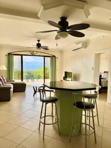 a living room with a ceiling fan and a table at Seaside Serenity 2b2b With Panoramic Terrace in Coco