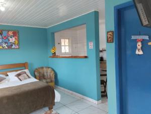 a blue room with a bed and a mirror at Pousada Cantinho da Mi & Teco in Campos do Jordão
