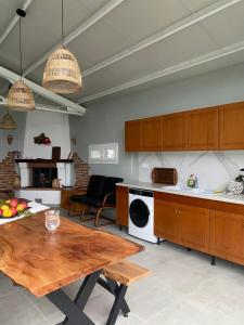 a kitchen with a wooden table and a microwave at Tennis Home-Pozar, Piperia! in Áno Rodoniá
