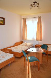 Cette chambre comprend deux lits, une table et des chaises. dans l'établissement Hotel Marco Płońsk Szkolna 115, à Płońsk
