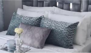 a white bed with pillows and a vase with a flower at Lerewa in Gaborone +21 photos