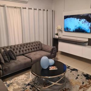 a living room with a brown couch and a tv at Lerewa in Gaborone