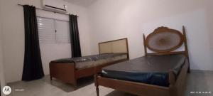 Un dormitorio con dos camas y una ventana en Casa Condomínio Praia Félix, en Ubatuba