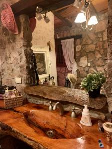 a stone bathroom with a sink and a mirror at Casa de ensueño in Villa Carlos Paz