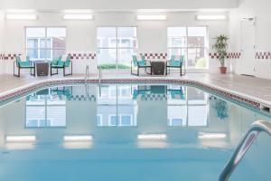 a pool in a hotel with chairs and tables at Residence Inn by Marriott Sioux Falls in Sioux Falls