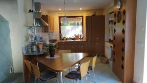 a kitchen with a wooden table and chairs in it at Rychwałd - Full House! in Rychwałd