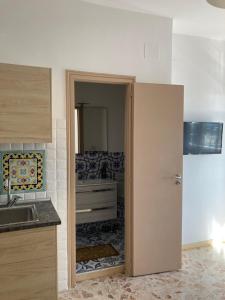 kuchnia z drzwiami prowadzącymi do łazienki w obiekcie casa vacanza brezza di maestrale w mieście Salerno +23 zdjęcia