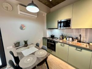 a kitchen with a table and a kitchen with a sink at All Green Loft with Amazing Views, With 2 Balconies and AC in Tbilisi City +24 photos