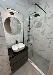 a bathroom with a sink and a shower with a mirror at All Green Loft with Amazing Views, With 2 Balconies and AC in Tbilisi City
