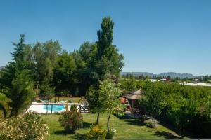 a garden with a swimming pool and a house at Complejo BenjaLuna in San Rafael