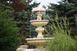 a fountain with a statue of a girl with an umbrella at Hotel Marco Płońsk Szkolna 115 in Płońsk