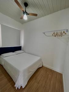 una camera da letto con un letto e un ventilatore a soffitto di Casa cinza a São Lourenço do Sul