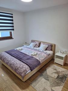 een slaapkamer met een bed met paarse lakens en kussens bij M&G Jahorina in Jahorina