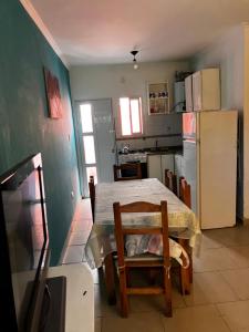 a kitchen with a table and a kitchen with a refrigerator at DuplexNico in Santa Teresita