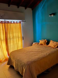 a bedroom with a bed with a yellow curtain at DuplexNico in Santa Teresita