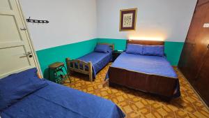 two beds in a room with blue sheets at Nueva Mansion Roca in Mendoza