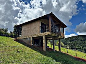 a house on the side of a hill at Chalés Recanto Vista do Valle in Monte Verde