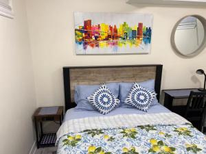 a bedroom with a bed with two pillows and a painting at Stylish City Escape in Toronto