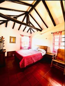 a bedroom with a bed and a chair in a room at Casa Piña in Villa de Leyva