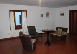 a living room with chairs and a table and a window at Hostal El Pino in Villa de Leyva +57 photos