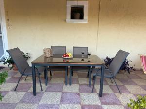 un tavolo con sedie e un cesto di frutta. di Golden Horizon Retreat, tranquil atmosphere next to the sea! a Gournes