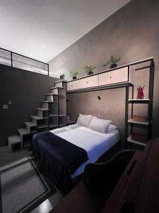 a bedroom with a bed and a staircase at Tulum jungle penthouse in Chemuyil