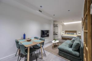 a living room with a couch and a table and a bed at ATyCO Madrid in Madrid