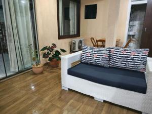 a living room with a white couch with pillows on it at Aconchegante casa de Temporada em Búzios. in Armacao dos Buzios