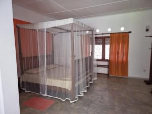 a bedroom with a canopy bed with curtains at GalleRetreat in Galle