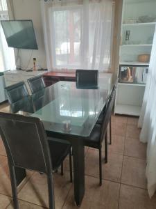 einen Esstisch mit Stühlen und einer Glasplatte in der Unterkunft Cabaña Bungalow SPA pasaje Las Pataguas in Quillón