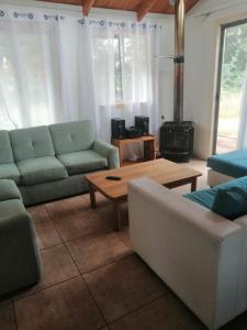 ein Wohnzimmer mit einer Couch und einem Couchtisch in der Unterkunft Cabaña Bungalow SPA pasaje Las Pataguas in Quillón