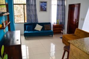 a living room with a blue couch in a room at Alojamiento Piquero Azul in Puerto Ayora