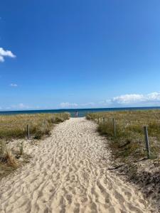 a sandy path leading to the ocean on a beach at Auf Feiningers Spuren durch das Mönchgut Doppelzimmer ohne Küche in Lobbe