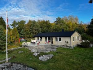 a small house with a flag in the yard at Delightful vacation home - boat - seaview - garden in Grimstad