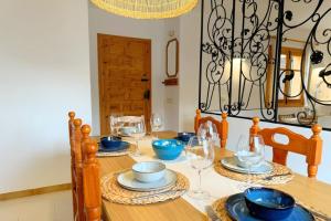 a dining room table with glasses and blue dishes on it at Incredible Views from La Parata in Mojácar