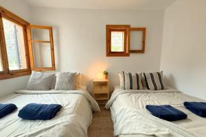 two beds in a bedroom with blue pillows on them at Incredible Views from La Parata in Mojácar