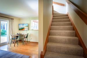 a staircase in a house with a dining room at Black Cottage - Beautiful Central Cottage for Two in Rotorua
