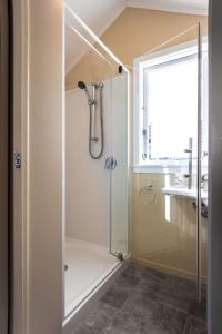 a bathroom with a shower with a glass door at Black Cottage - Beautiful Central Cottage for Two in Rotorua